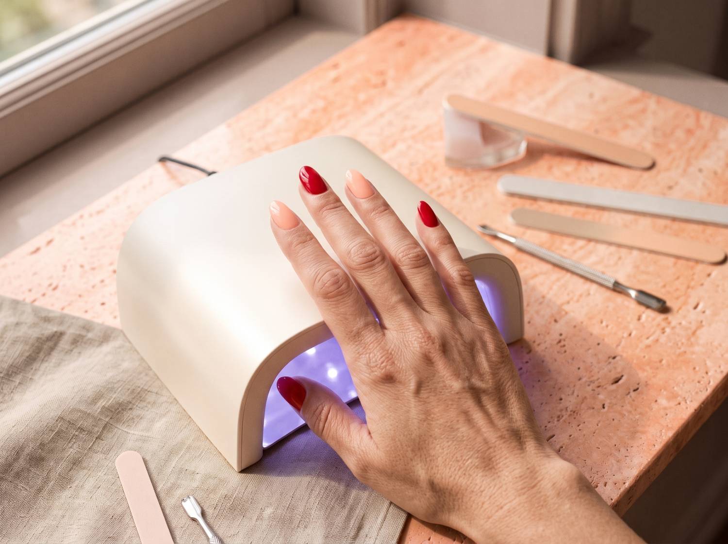 Illustrative glossy manicure under a nail lamp